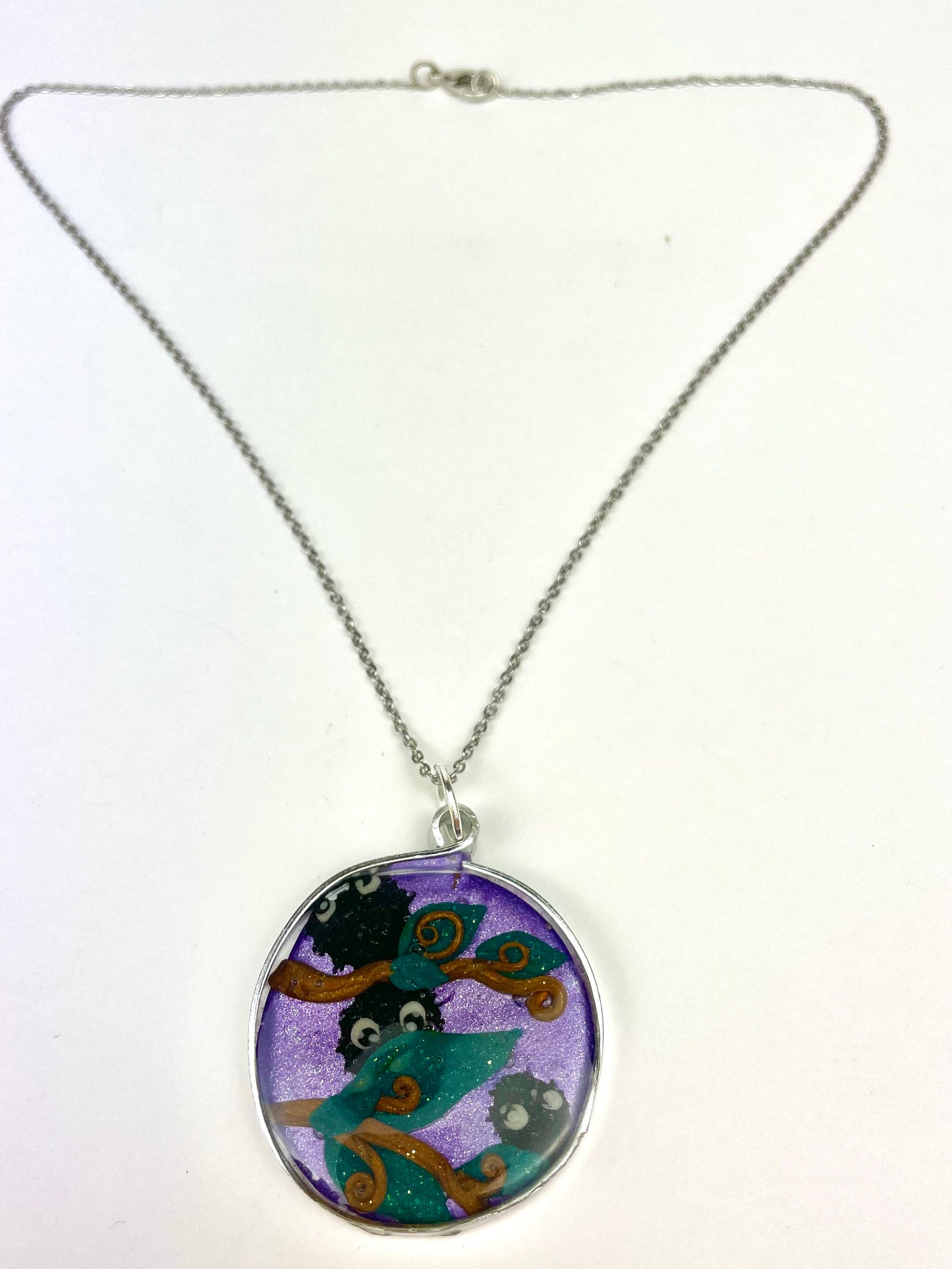 Pendentif rond décoré des noiraudes de l’univers Ghibli, pièce unique artisanale.