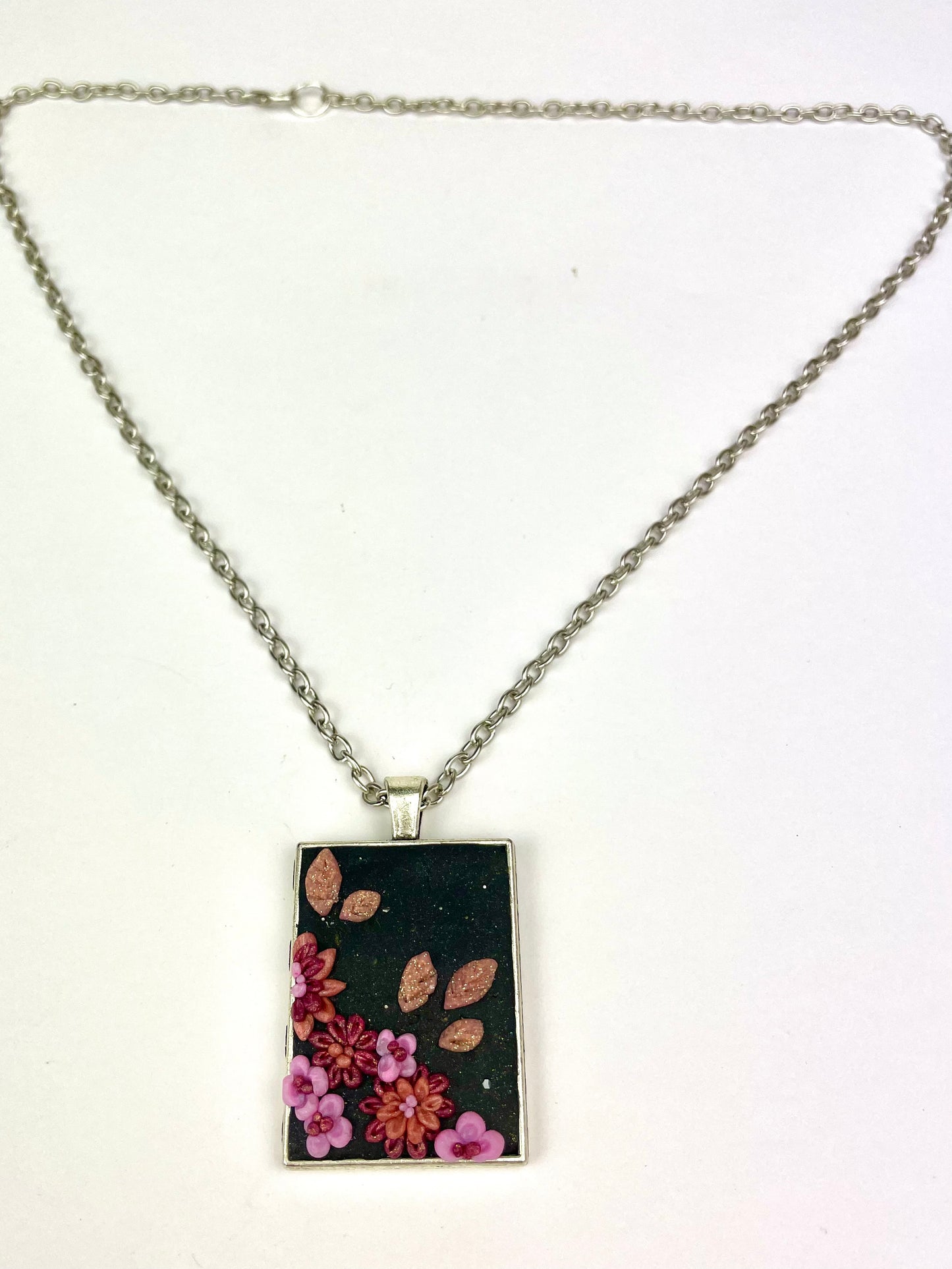 Collier Rose de nuit avec médaillon rectangulaire fleuri.