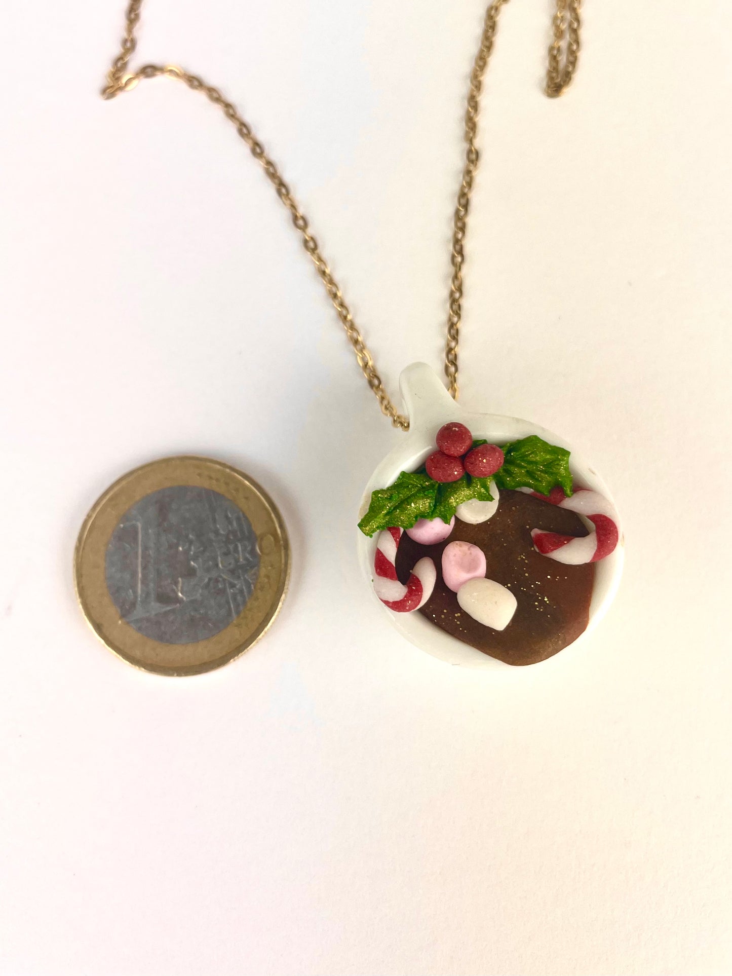 Détail du médaillon dinette de Noël avec houx, marshmallows et sucre d’orge, collier artisanal unique.