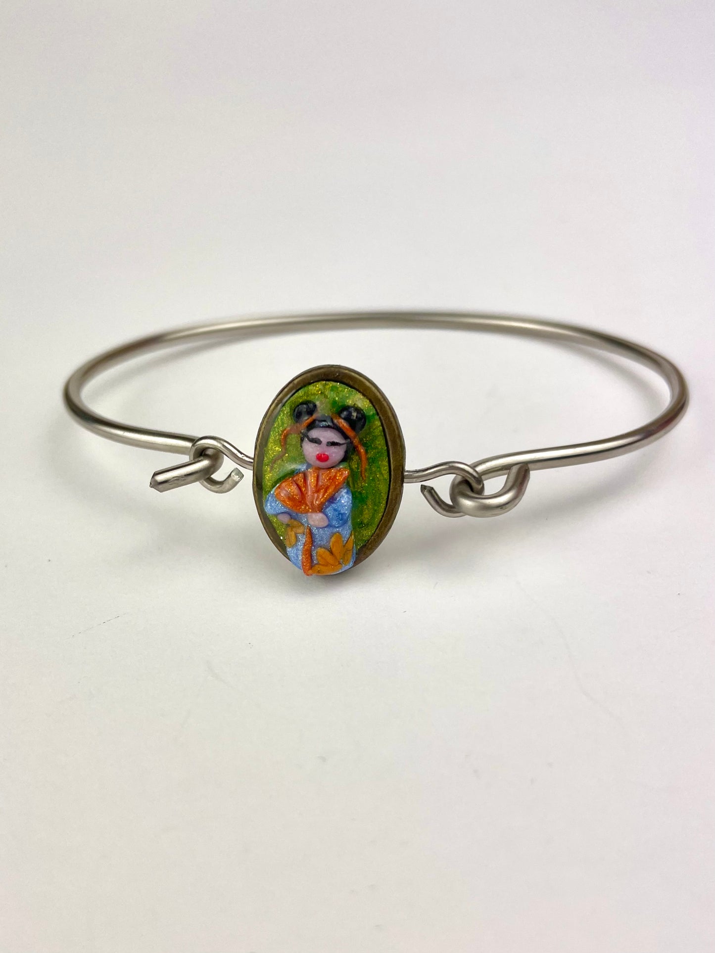 → Détail du cabochon Poupée Kokeshi en pâte polymère – bracelet argenté fait main