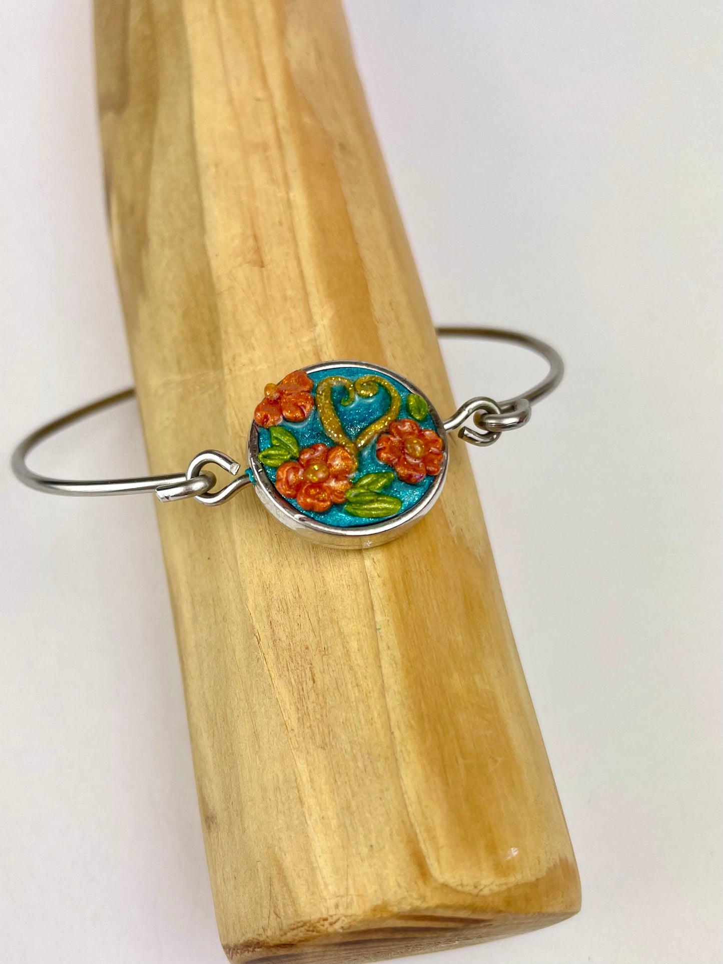 Bracelet artisanal Caraïbes – motif fleurs orange sur fond turquoise