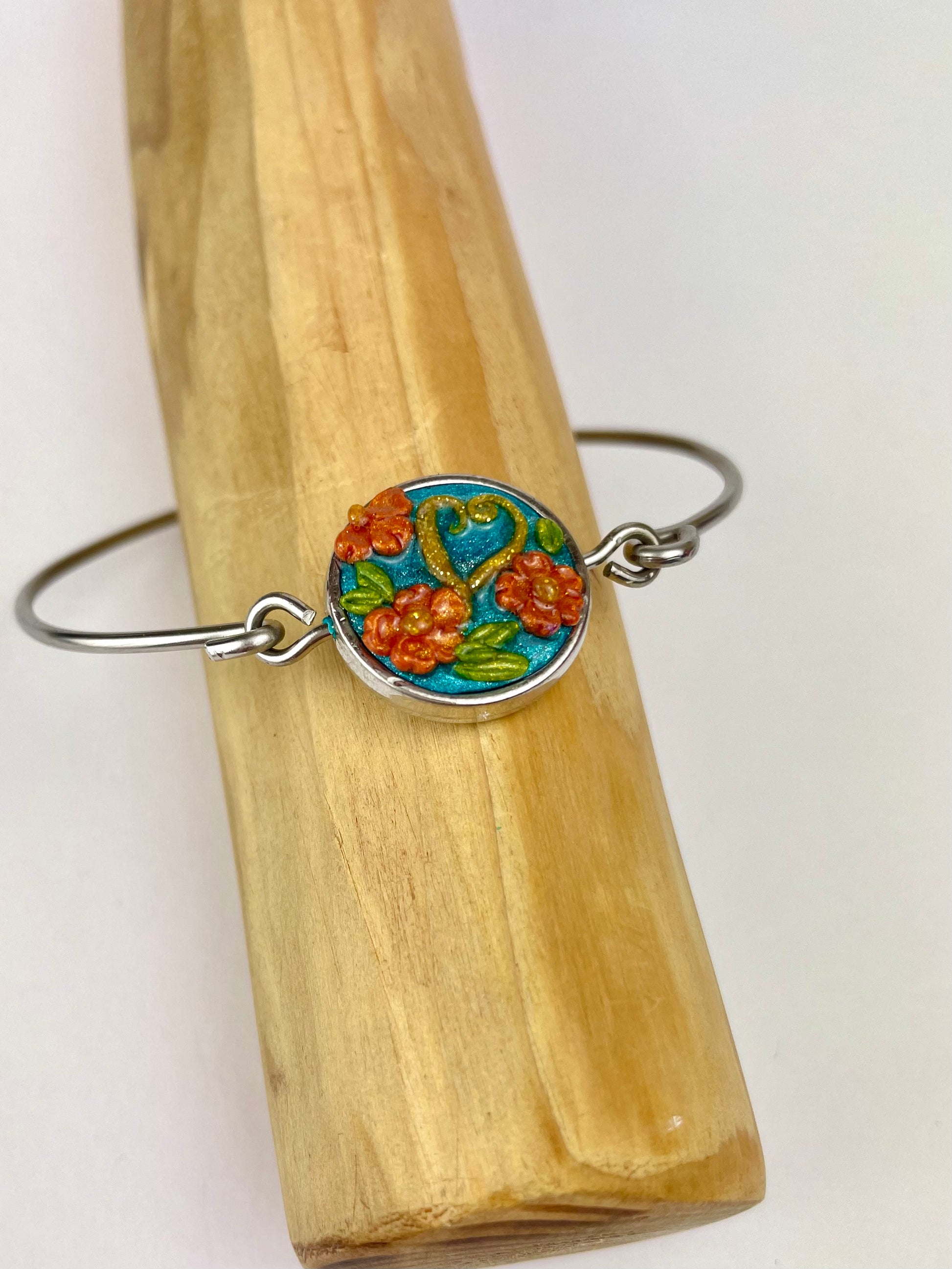 Bracelet artisanal Caraïbes – motif fleurs orange sur fond turquoise