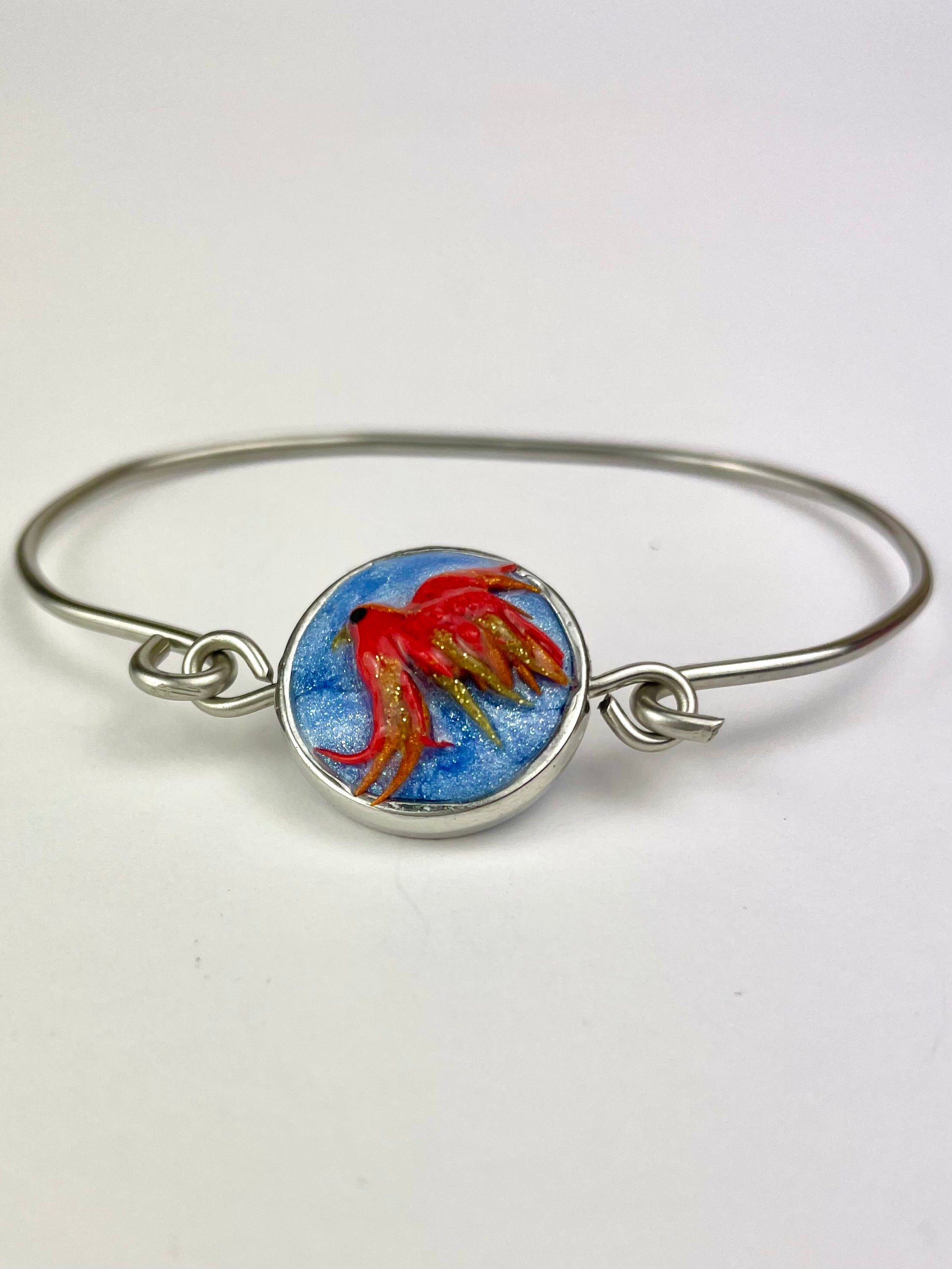 Détail du cabochon phénix rouge et orange en pâte polymère – bijou artisanal