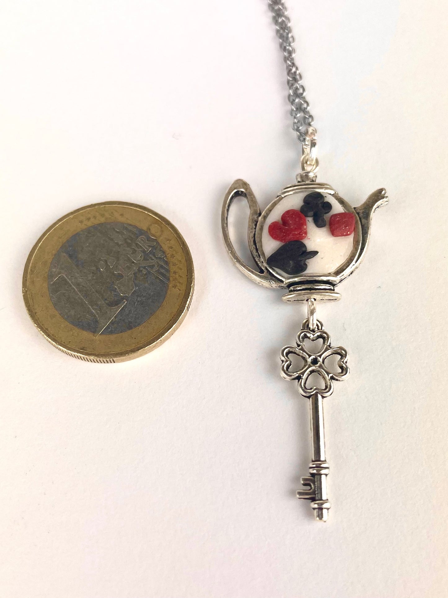 Détail du médaillon en pâte polymère inspiré d’un jeu de cartes du Pays des Merveilles.