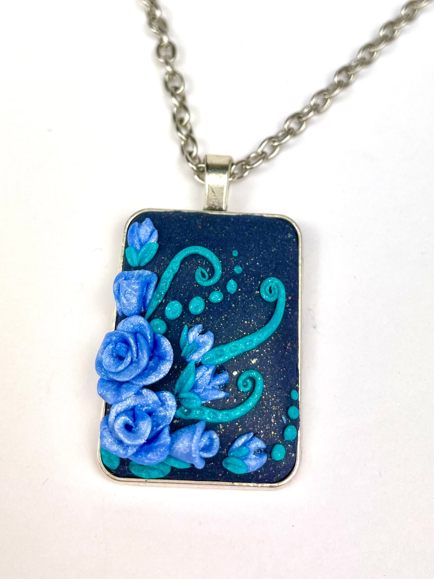 Médail­lon carré bleu nuit avec rose bleue sculptée en pâte polymère