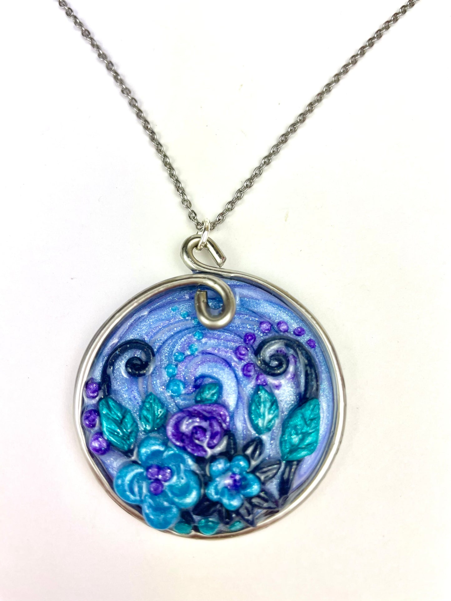 Médaillon bleu artisanal avec spirales et fleurs sculptées à la main