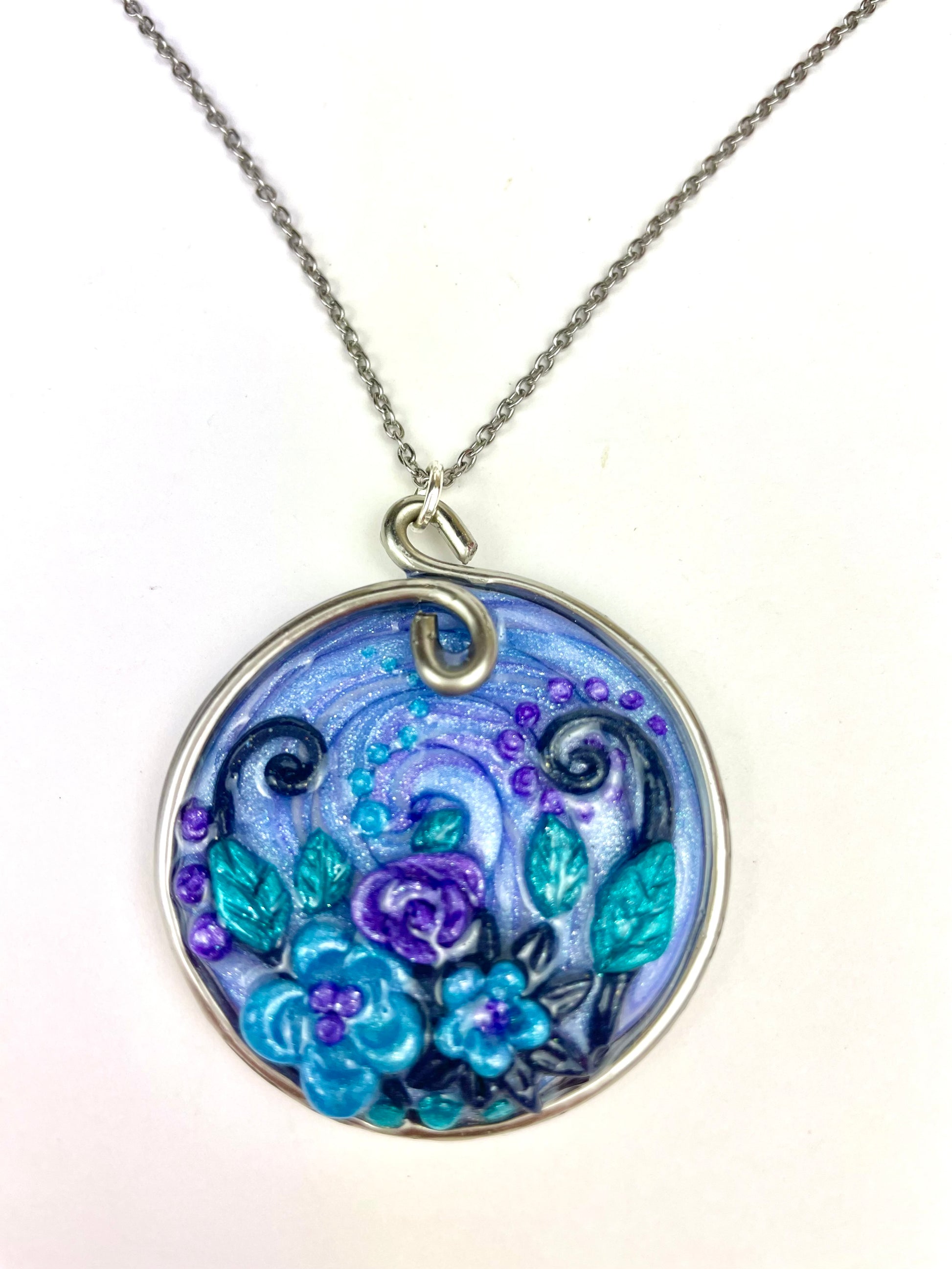 Médaillon bleu artisanal avec spirales et fleurs sculptées à la main