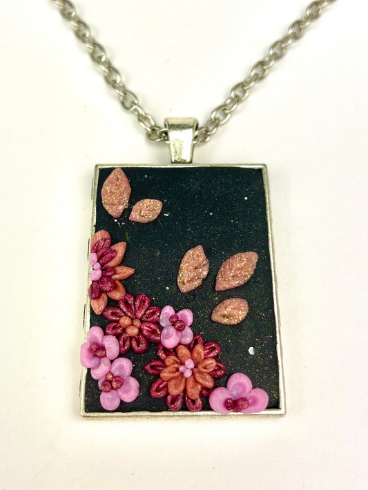 Médaillon Rose de nuit avec fleurs roses sculptées sur fond noir.