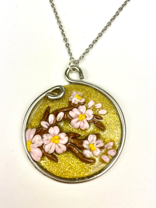 Médaillon Sakura avec fleurs de cerisiers en relief, bijou artisanal fait main.