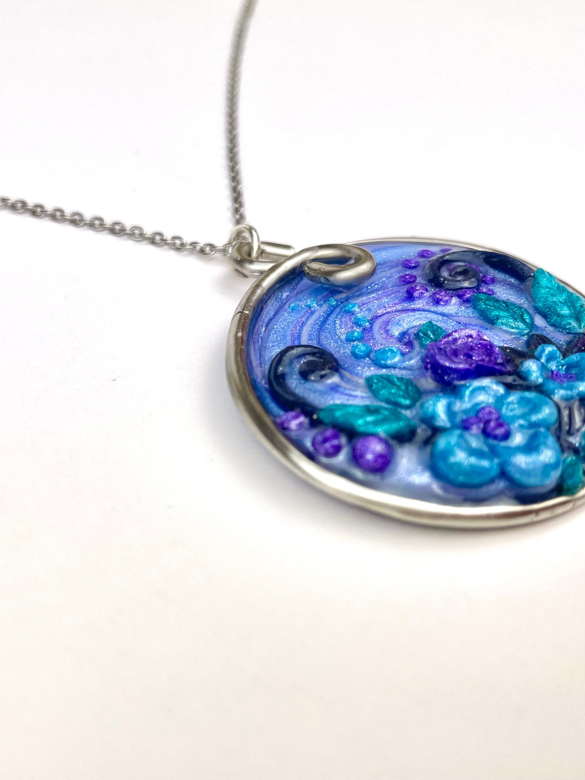 Pendentif rond bleu turquoise et violet sculpté en pâte polymère