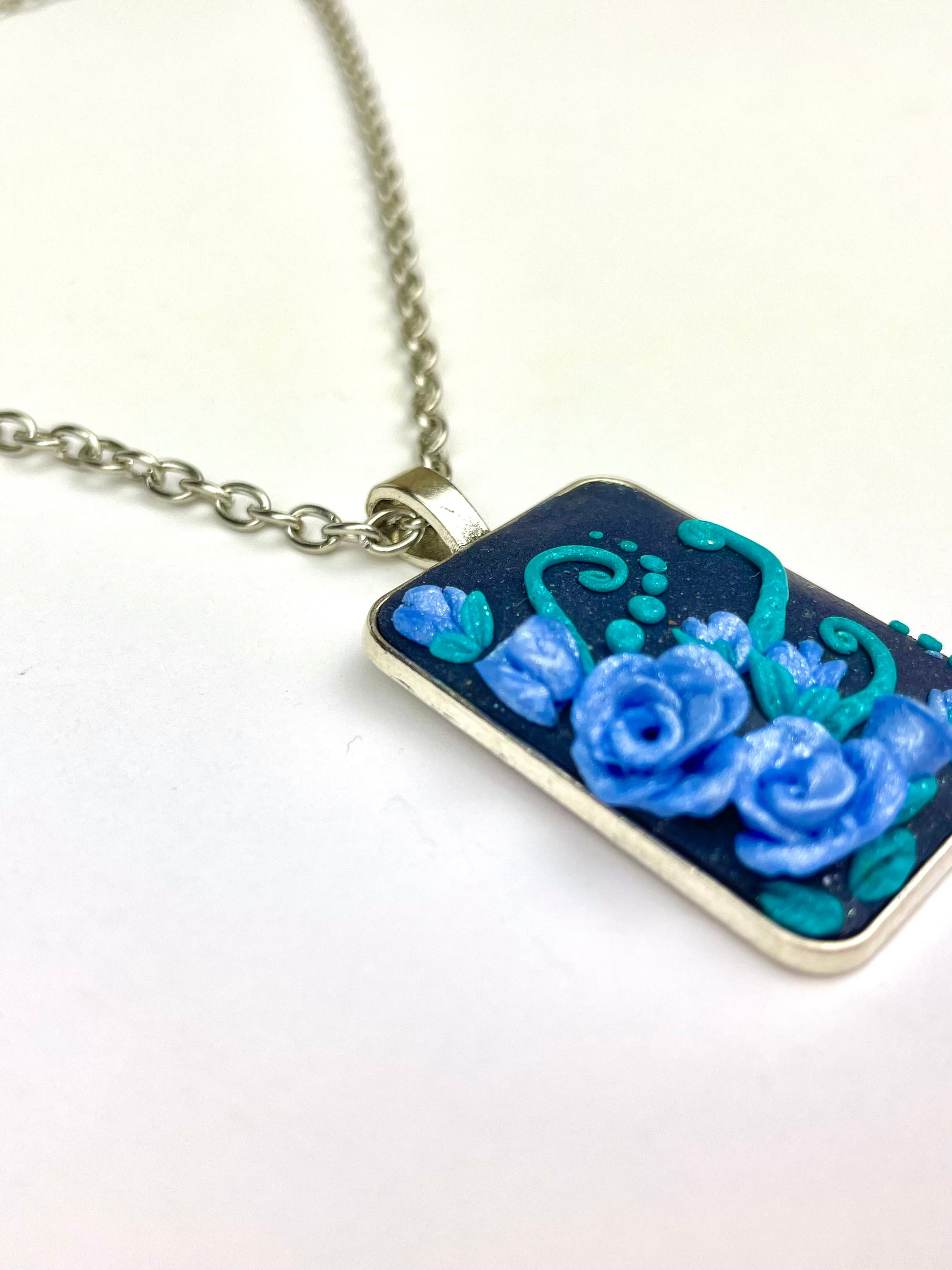 Pendentif fait main avec rose bleue et arabesques turquoise