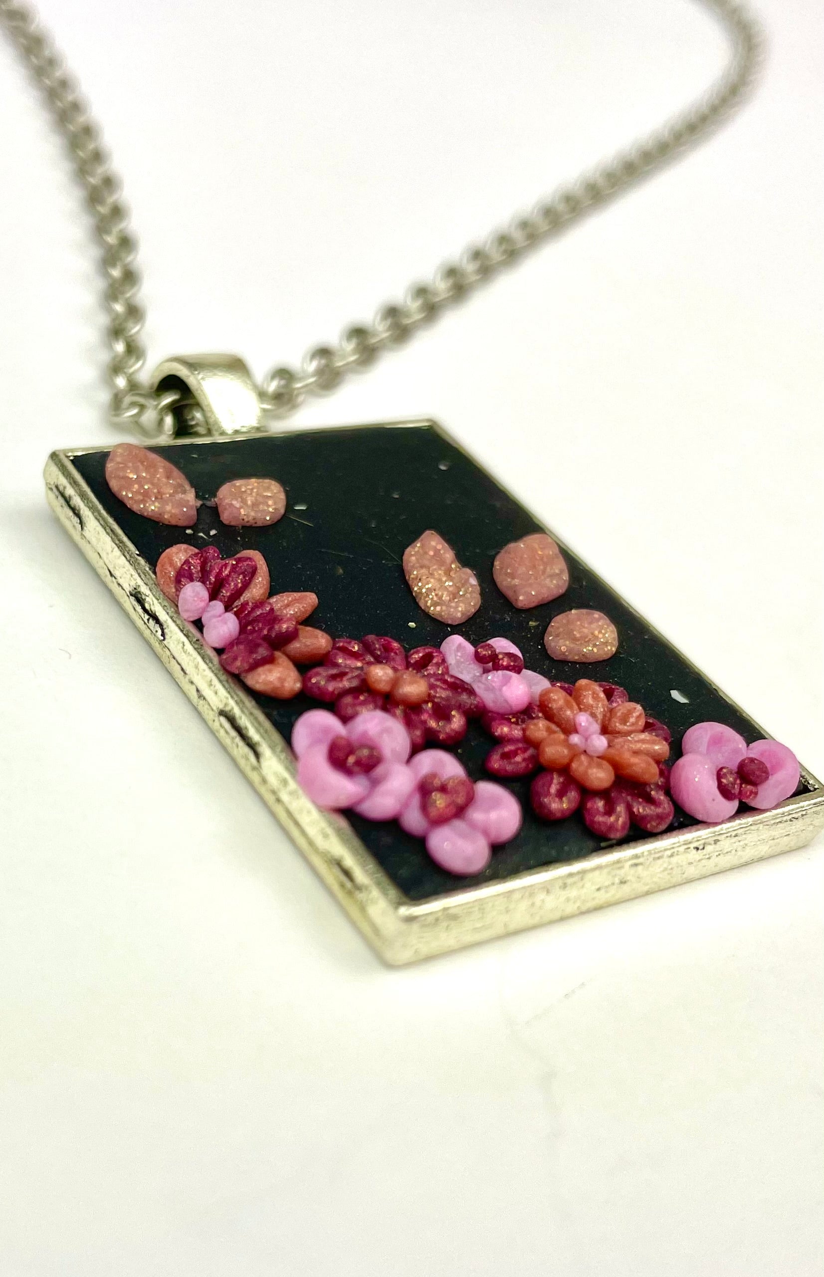 Bijou artisanal Rose de nuit vu en angle montrant les détails floraux.